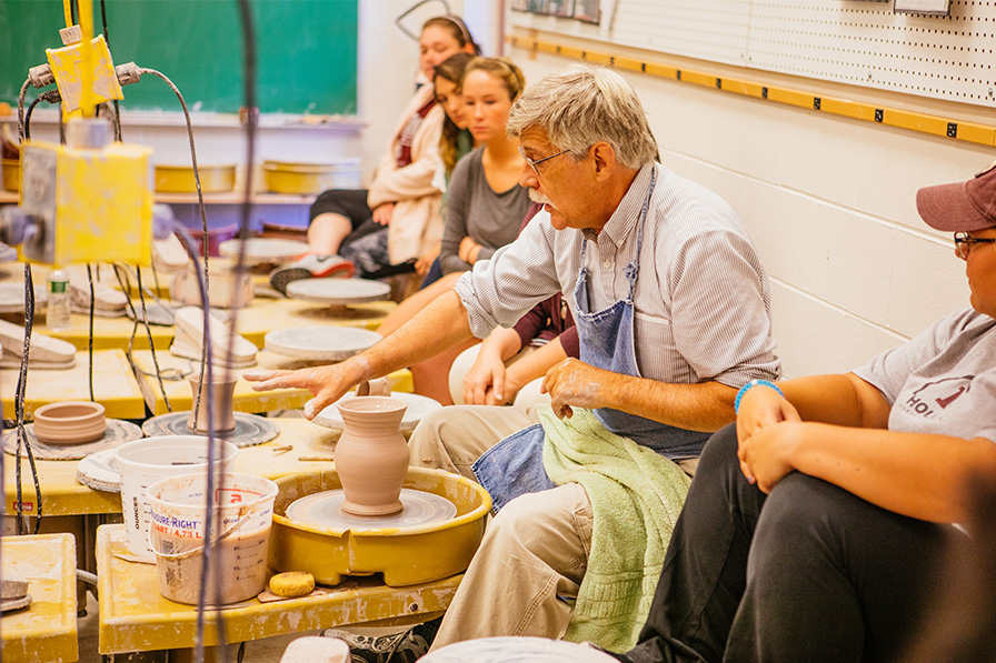 Professor and students in ceramics studio