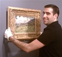 Brandon Adams hanging a painting