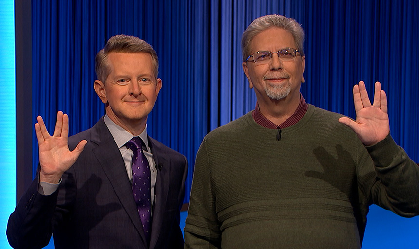 Professor Hollis pictured with a Jeopardy! host as both make the Vulcan hand salute from Star Trek