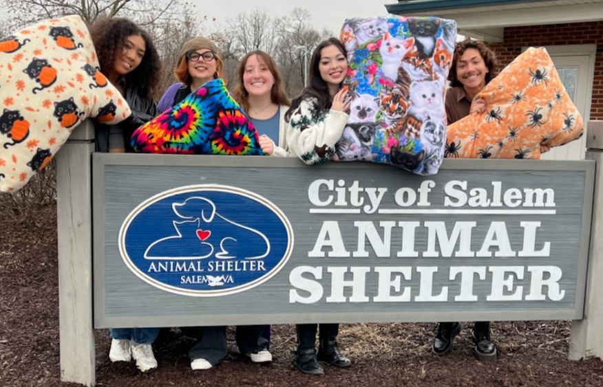 Students with Pet Beds stand at Animal Shelter sign