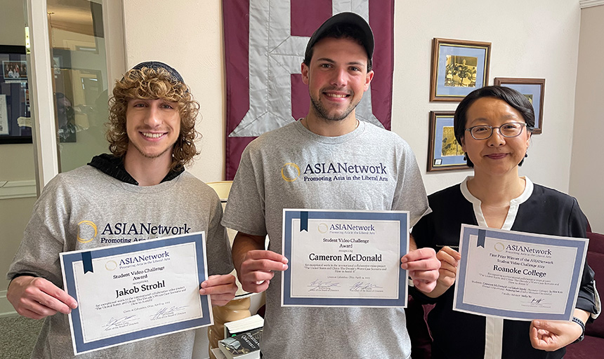 Jakob Strohl, Cameron McDonald and Stella Xu stand next to one another and smile while holding up the ASIANetwork award certificates