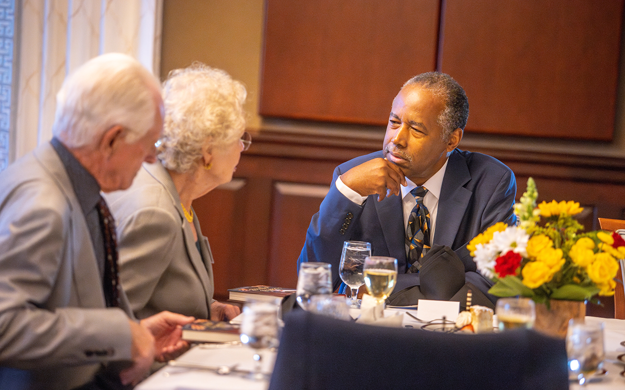 Ben Carson listens to dinner guests