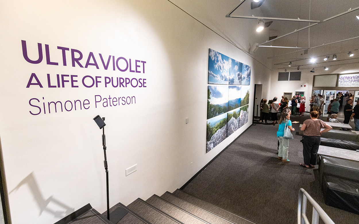A closeup of the gallery entrance bearing a sign that reads: Ultraviolet A Life of Purpose Simone Paterson