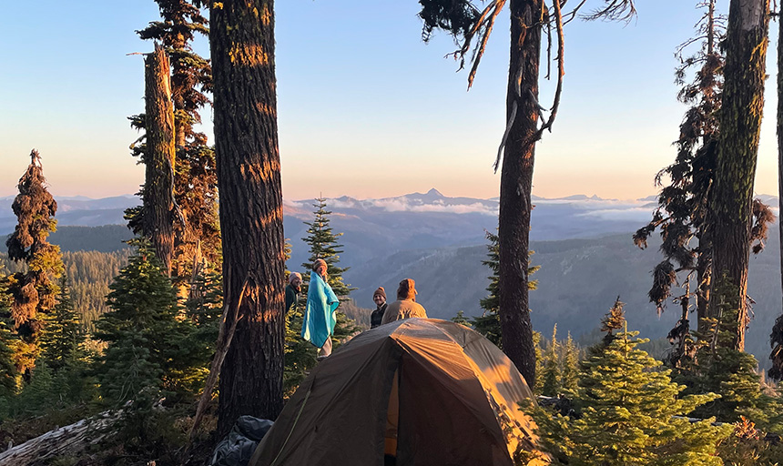 Students on a camping trip rising to greet the sunrise over a mountain overlook
