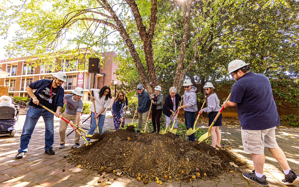 Students, alumni and other community members wield golden shovels while taking part in the ceremonial groundbreaking