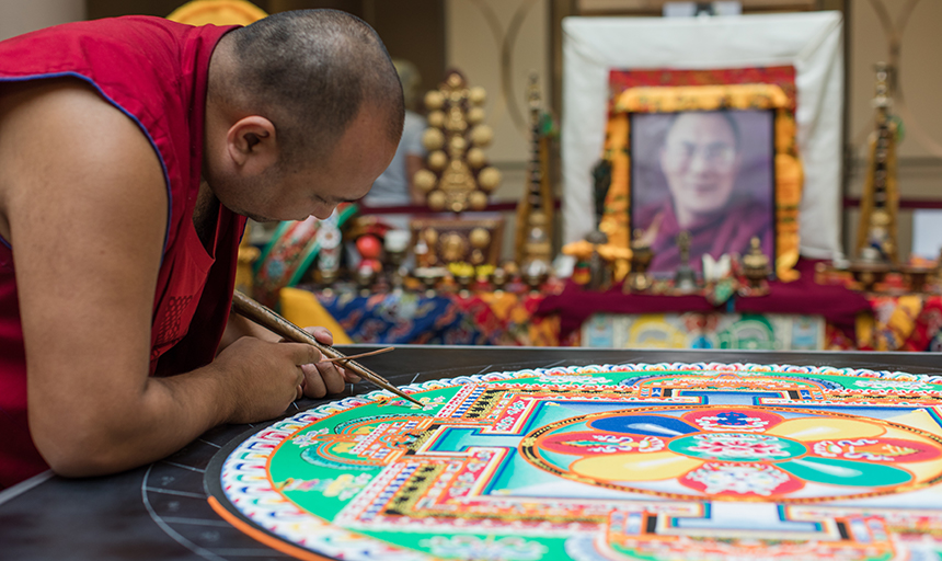 Tibetan monk works on sand mandala
