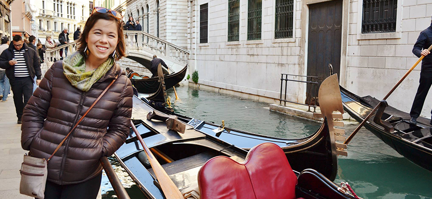Jessica Compton smiles next to a gondola while traveling