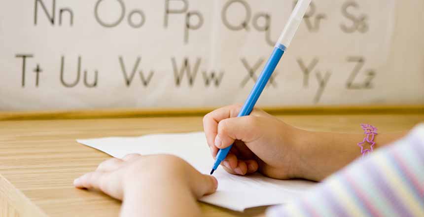 Elementary school student practicing writing the alphabet