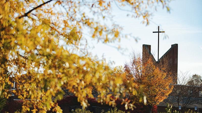 Cross of Antrim Chapel framed by fall trees