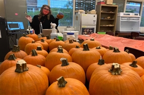 student with a lot of pumpkins
