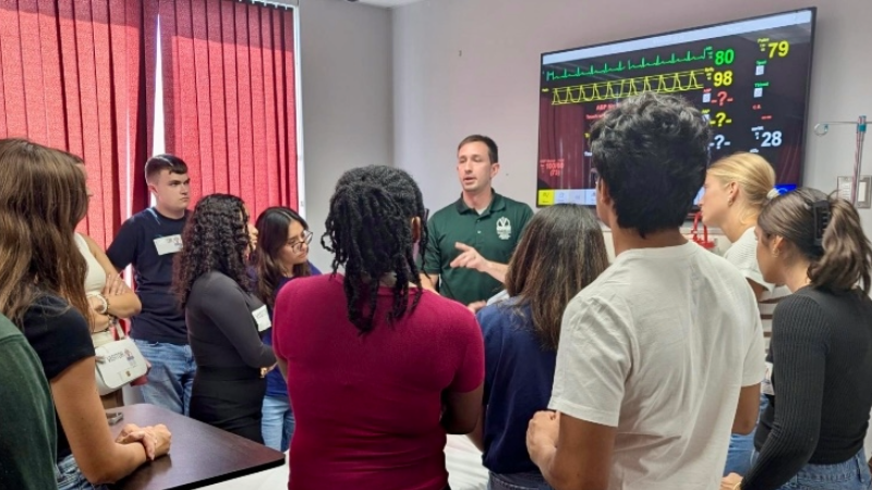 Students listening to an instructor in a healthcare simulation lab