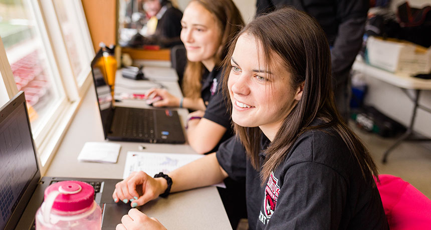 Students working as stat crew at sports game