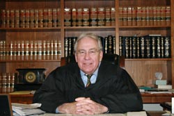 Judge Humes Franklin, Jr. in front of a bookshelf full of books