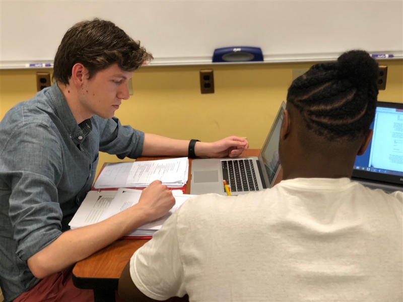 two students studying side-by-side at table