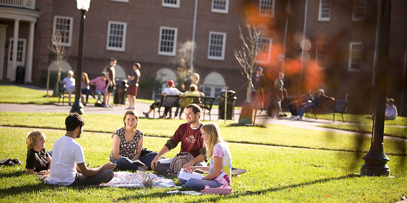 students sitting outside the Wortmann complex doing homework and chatting