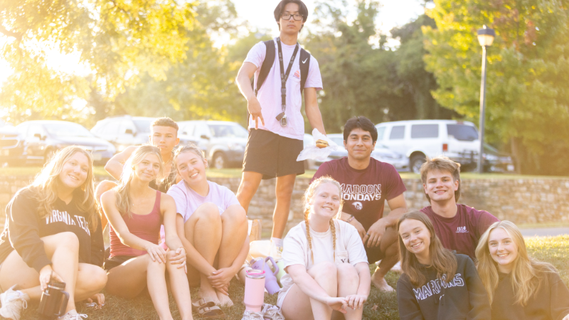 Fraternity and sorority members smile for a photo during a Greek Week event