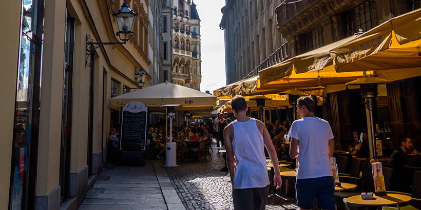 Students walking down a street with tall buildings on either side