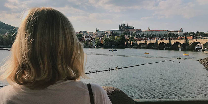 A student overlooking a canal and a large building