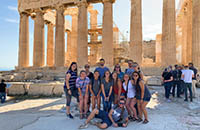 Group of students standing in front of Greek Ruins