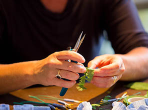 Talia Logan, demonstrates how to cut different parts of flowers for volunteers of The Paper Blooms Project