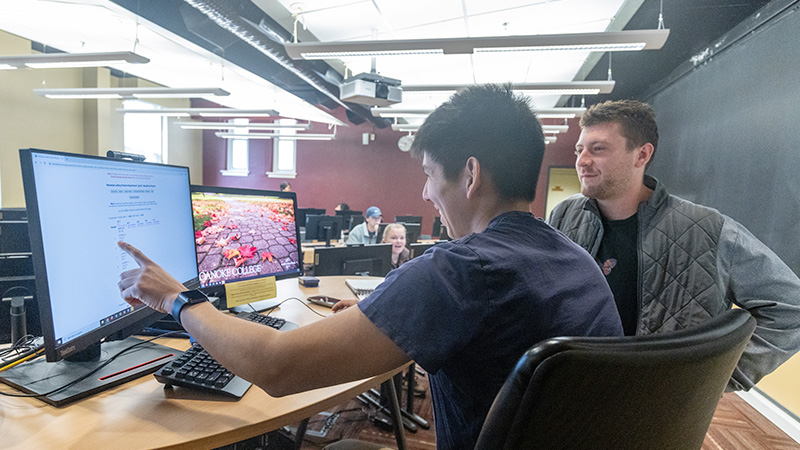 Two students working together in a computer lab