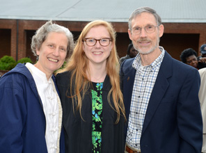 student posing for a picture with her parents