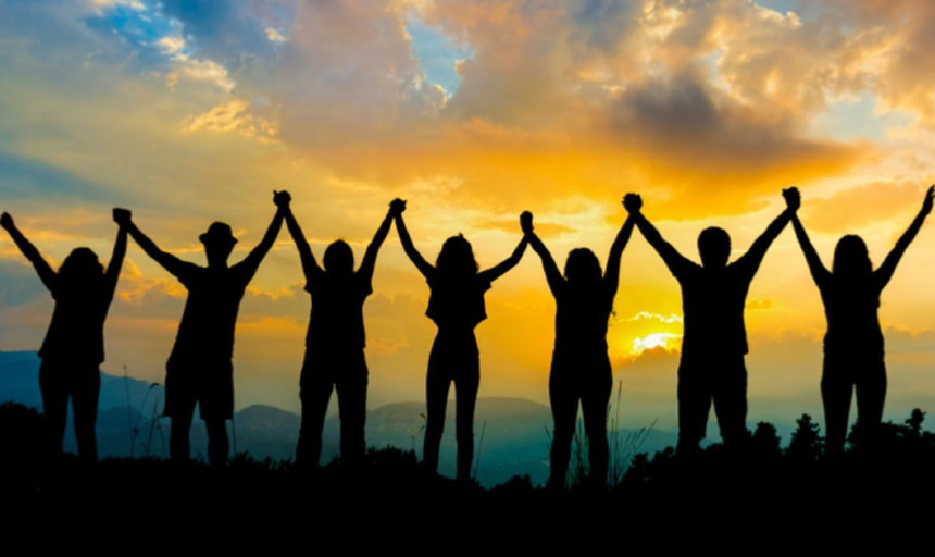 People holding hands against the sunset