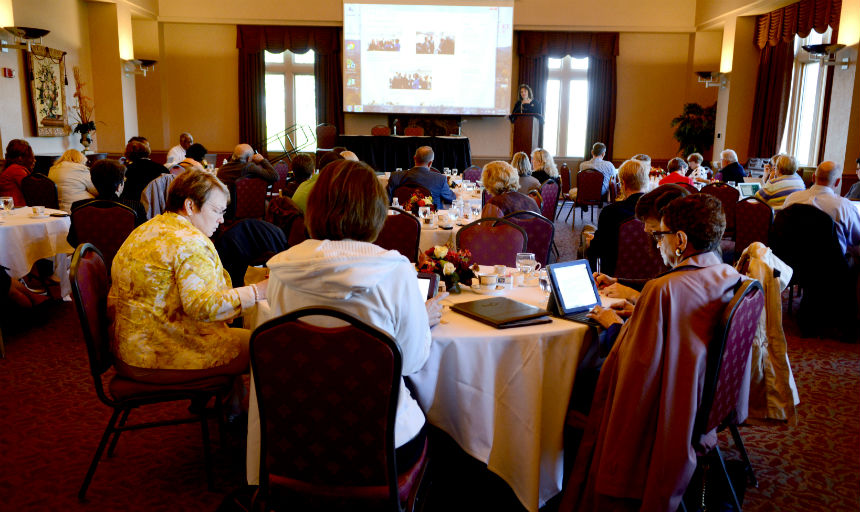 Teachers sitting around table looking at a powerpoint