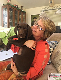 Photo of Sarah Payne with a dog in her lap