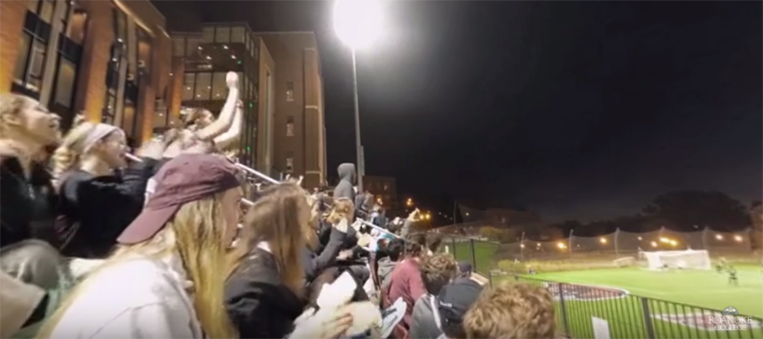 Students in the bleachers cheer during a sports game