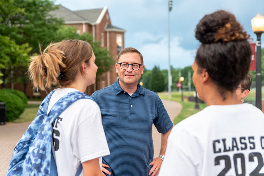 President Shushok talking to two students