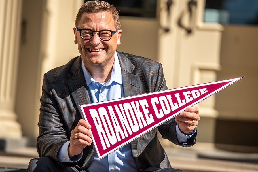 President Shushok holding Roanoke College pennant