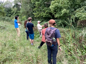 Students gathered along a grassy swale