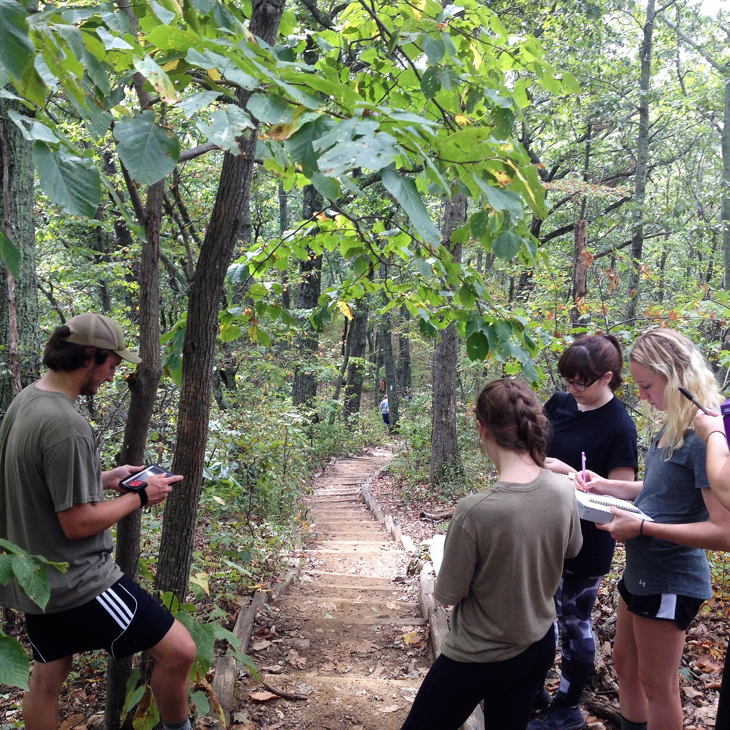 Students taking notes on the fauna found on the hiking trail