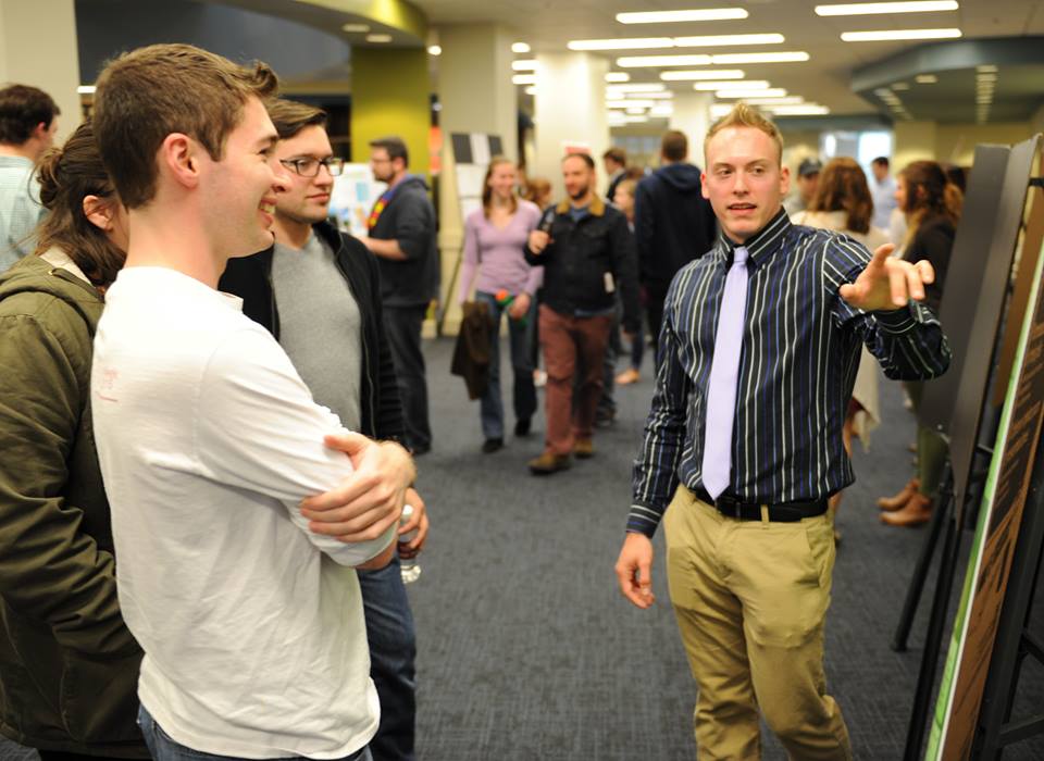 Student explaining his research to another student