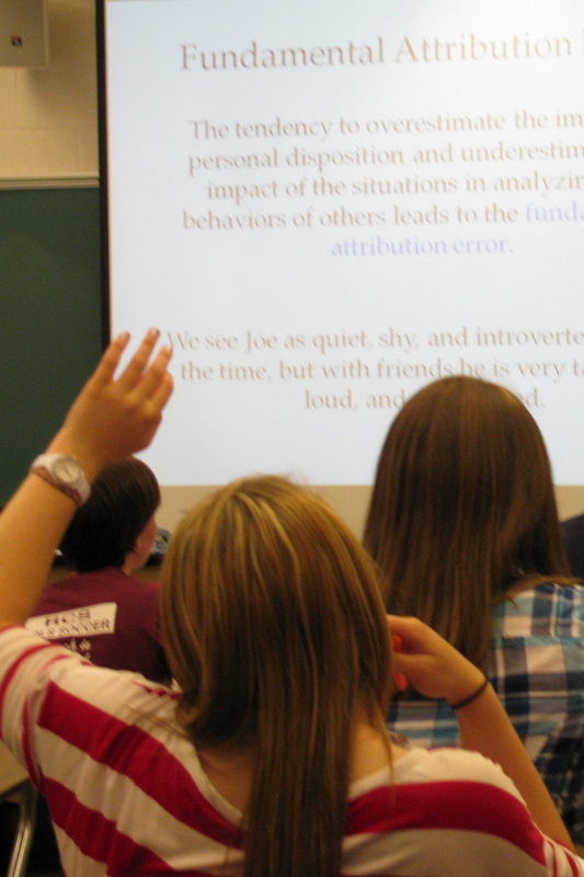 student raising her hand in class