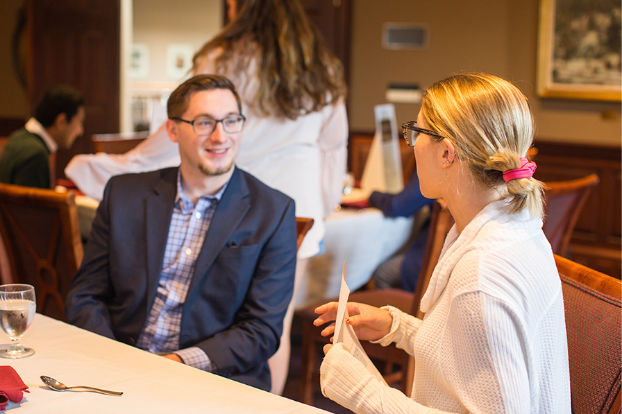 people talking with one another at a banquet event on campus