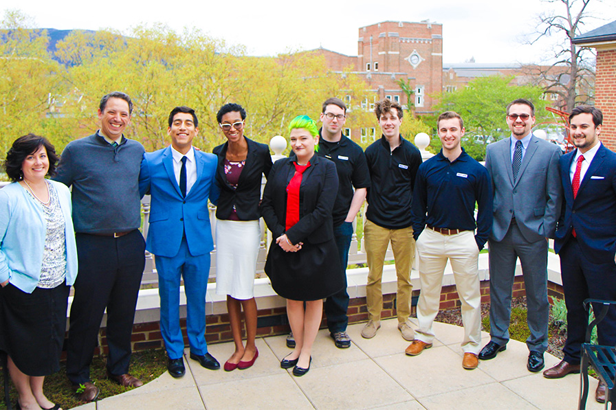 students and faculty smile for a group photo