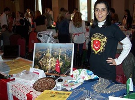 A student standing at a table at a study abroad fair