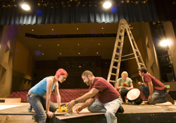 a crew constructs a stage set