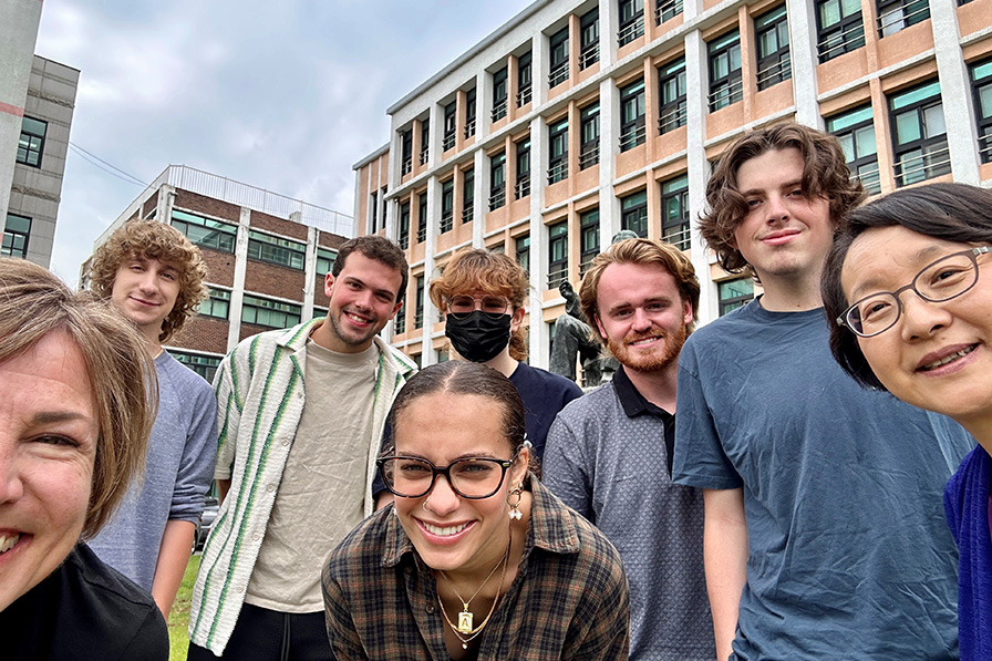 students and professors smile for a group photo