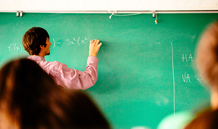 Professor writing on board.