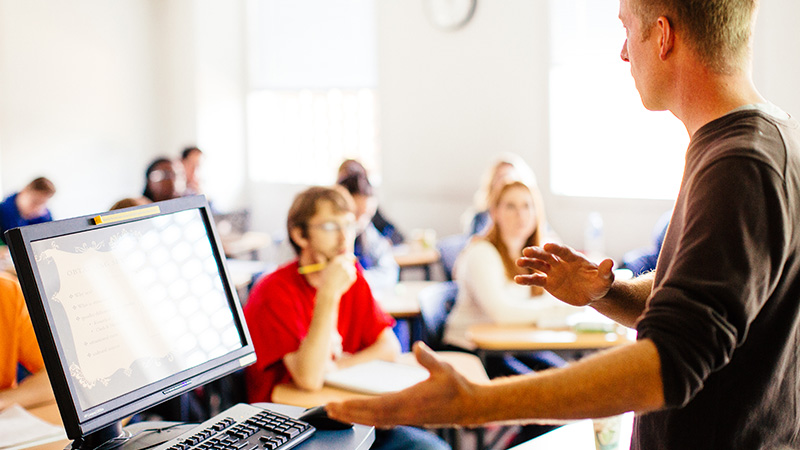 Students listen attentively as a psychology professor teaches in a classroom