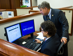 Ian Kervick-Jimenex ‘13 on the computer being assisted at his internship