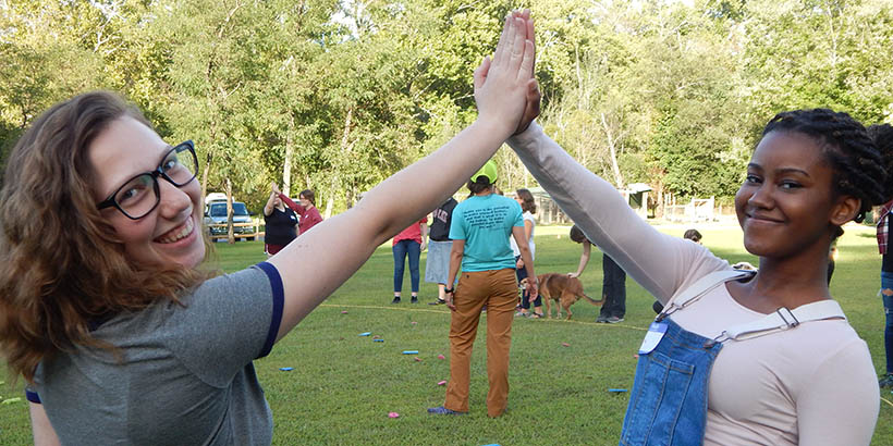 Two students high-fiving each other and smiling