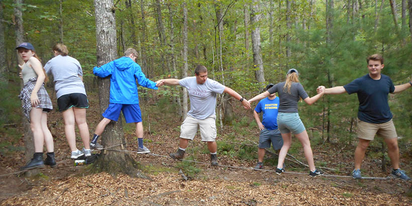 Students participating in a ropes course