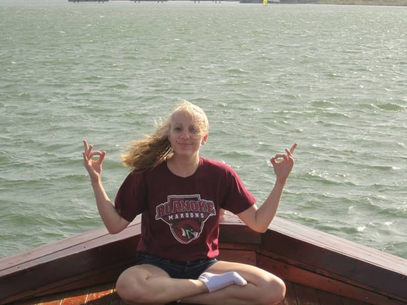 Student sitting on a boat on a river