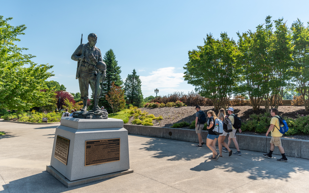 students walking by statue