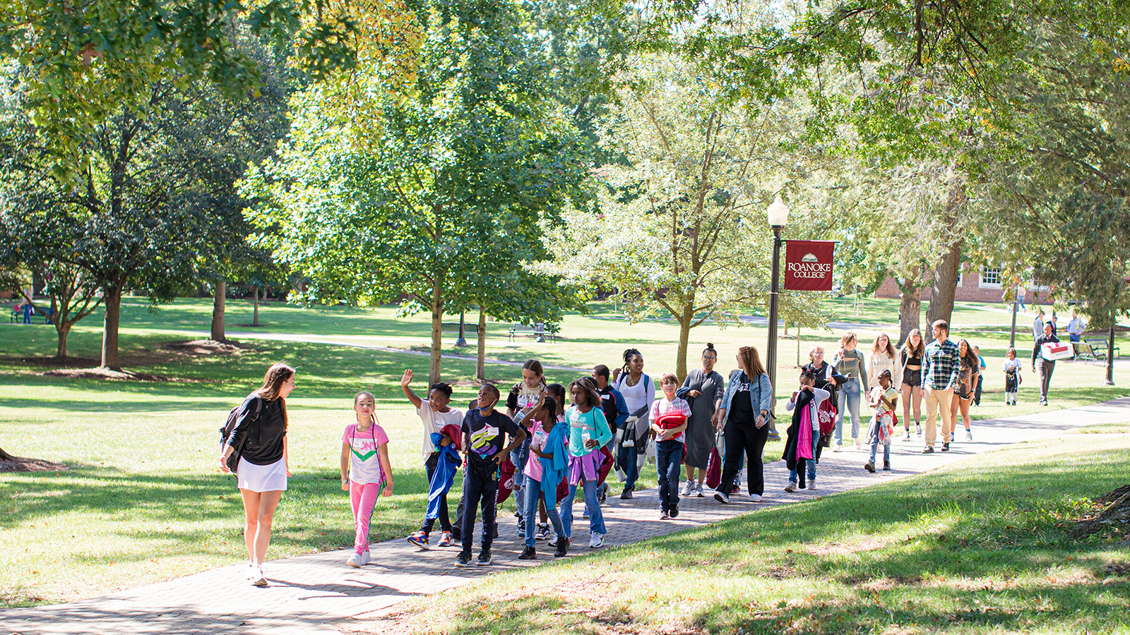 Students walking with children on campus 
