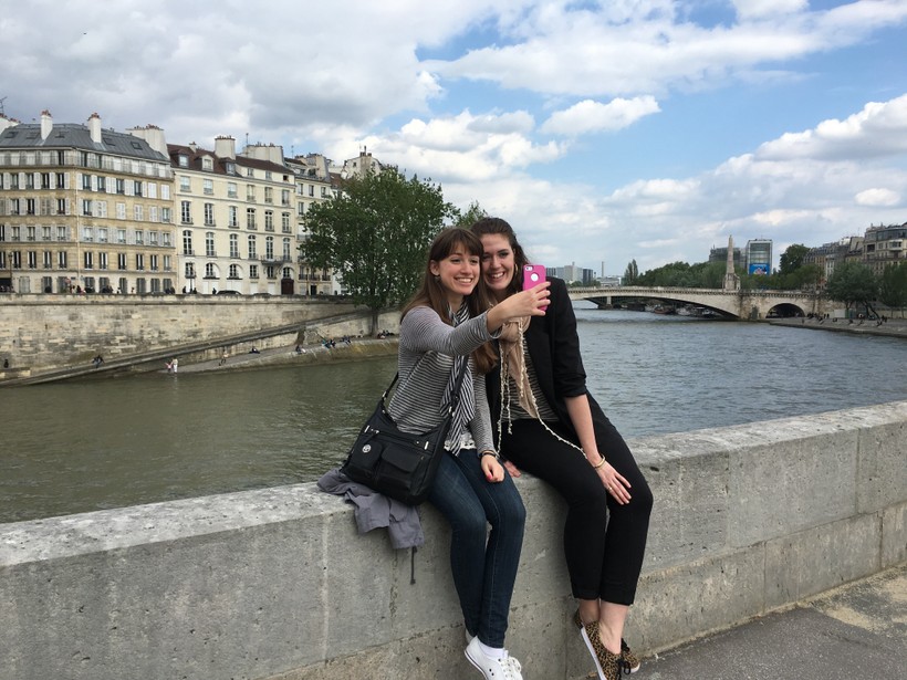 Two students taking a selfie by the river Seine